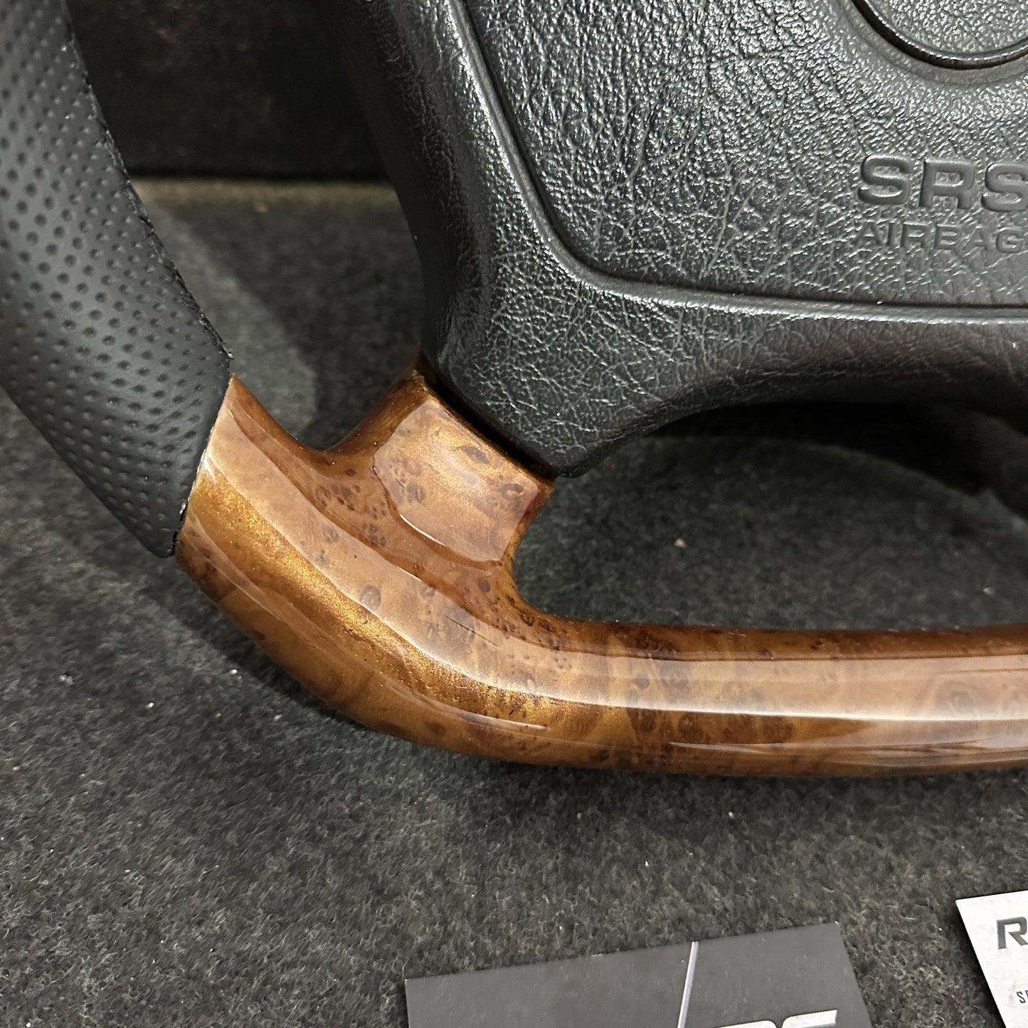 Deep-grain Burl Wood finish on a custom Mercedes-Benz steering wheel, professionally clear-coated for a high-gloss, durable mirror reflection.
