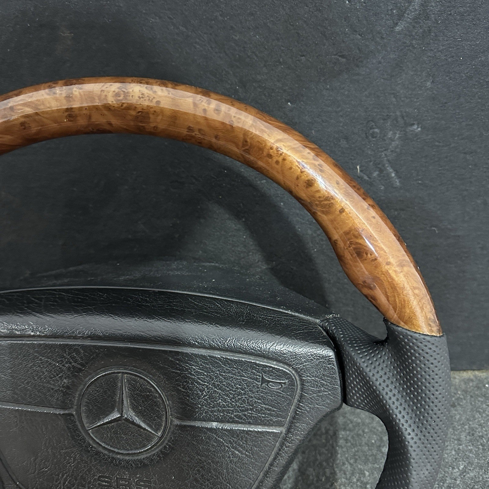 Deep-grain Burl Wood finish on a custom Mercedes-Benz steering wheel, professionally clear-coated for a high-gloss, durable mirror reflection.